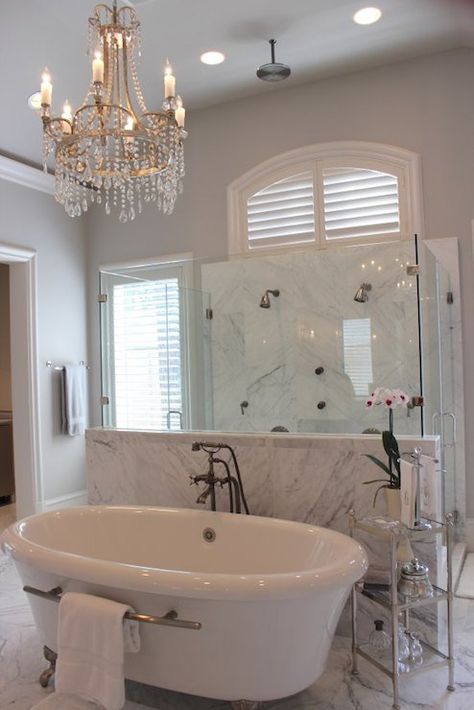 Gorgeous en-suite bathroom boasts crystal chandelier over claw foot tub accented with towel bar paired with floor-mounted tub filler along with nickel and glass etagere placed in front of walk-in shower. Crystal Bathroom Lighting, Crystal Bathroom, Bathroom Chandelier, Luxury Bathroom Interior, Best Kitchen Design, Master Bathrooms, Towel Bars, Bad Design, Dream Bathrooms