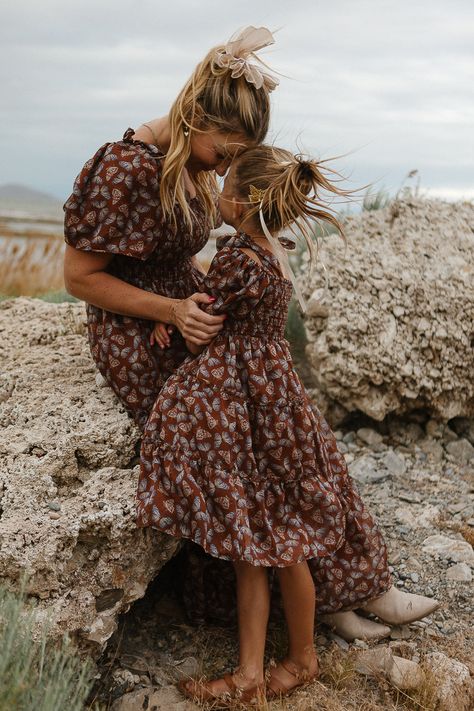 Let your little one flutter into fall with the Mini Daydreamer Dress in Monarch! This brown butterfly print chiffon dress features a sweet square neckline, a smocked bodice for a comfy fit, and a midi-length skirt for endless autumn adventures. Plus, there’s a matching dress for mom—perfect for twinning on those crisp fall days! Mommy And Me Fall Dresses, Fall Picture Dresses For Women, Brooke Schultz Photography, Mom And Child Aesthetic, Mom And Daughter Fall Photoshoot, Fall Family Photos Burgundy, Fall Western Family Photos, Fall Dress With Boots, Neutral Family Picture Outfits