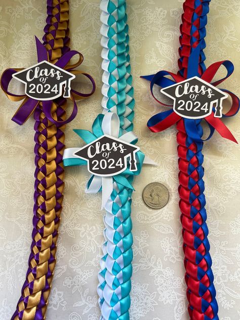 Width: 1 inch Length: 38 inches  Made from 3/8" ribbon Larger 5/8" Version here:  https://808jemcreationsllc.etsy.com/listing/1736972433 This lei is slightly different from my other single braided listings. This one has a bow with added ribbon surrounding it and the class of 2024 will be placed on top. The graduation caps are made from cardstock.  You can choose up to 2 colors (See photo for color options) and every lei will come with the graduation cap already on them. I hot glue the caps direc Ribbon Graduation, Pink Notepad, Diy Graduation Gifts, Custom Graduation Gift, Ribbon Lei, Graduation Candy, Graduation Leis, Graduation Favors, Label Christmas