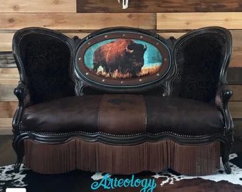 https://arteology.biz by ArteologyDesigns on Etsy Southwestern Chairs, Cowhide Decor, Antique Settee, Vintage Settee, Reupholster Furniture, Western Furniture, Gold Nail, Buffalo Nickel, Black Cow