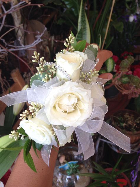 White and silver wrist corsage by Mariam's Flowers. White Flower Corsage Prom, Navy Corsage, White And Greenery Wrist Corsage, White And Silver Corsage And Boutonniere, White And Silver Corsage, Corsage Wedding White And Green, Black White And Silver Corsage, Silver Corsage, Gold Corsage