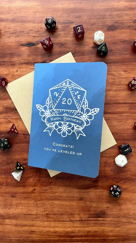 Delight your favorite adventurer with our D&D-themed d20 Happy Birthday Card! 🎉🐉 Featuring the iconic d20 dice and the message 'Congrats! You've leveled up,' it's a critical hit of celebration and fun. Get yours now and roll in the birthday cheer! What you get: - Handmade 5x7 greeting card - Printed on high-quality 218gsm cardstock - Also comes with a self-sealing kraft envelope - Blank Inside Your card will be mailed in a rigid mailer via USPS along with a tracking number. D&d Birthday Card, Cricut 2023, Dnd Birthday, Happy Birthday Cards Handmade, Nerd Games, Board Game Night, D20 Dice, Frida Kahlo Art, Birthday Cheers