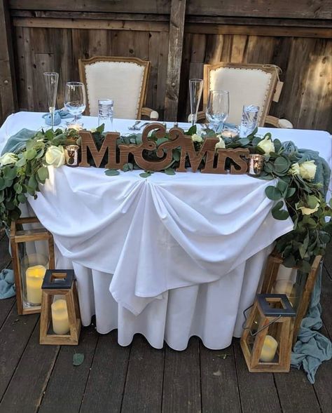 Sweetheart Table Wedding Flowers Simple, Wedding Arbor Behind Sweetheart Table, Mrs And Mr Wedding Table, Rustic Bridal Table Ideas, Bride And Groom Table Decorations Simple, Couples Wedding Table Ideas, Rustic Sweetheart Table Decor, Rustic Wedding Sweetheart Table Ideas, Me And Mrs Table Wedding Ideas