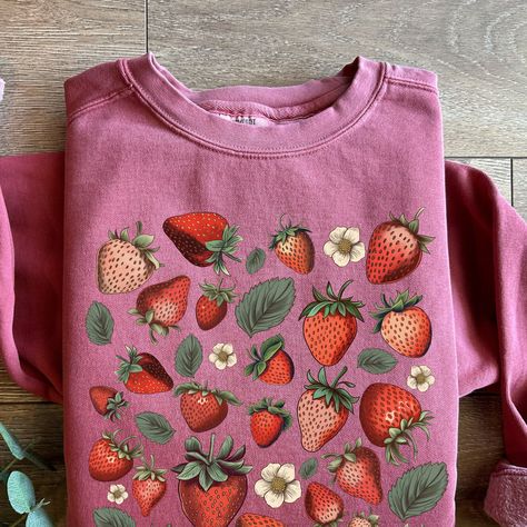 Trendy Comfort Colors crewneck sweatshirt with the sweetest strawberry print :)  Relaxed fit with OEKO-TEX certified low-impact dyes and a sewn in twill label ✨ Free shipping!✨  ✨ Important:✨  Product color may vary slightly due to variation in photographic lighting and screens/monitors displaying colors differently. When ordering and choosing your size, please keep the unisex fit in mind. These Comfort Color sweatshirts are relaxed fit and can be looser/slightly oversized compared to other crewneck sweatshirts (Gildan 18000 for example). Sizes may vary by 1.5 inches from pictured size chart.  Caring for your sweatshirt:  Turn inside out, machine wash in cold water  with mild detergent on gentle and hang to dry. Thank you for choosing my shop ❤️ Strawberry Print Clothes, Strawberry Aesthetic Outfit, Colorful Crewneck, Strawberry Sweater, Crewneck Aesthetic, Strawberry Shirt, Comfort Colors Sweatshirt, Strawberry Print, Comfort Color