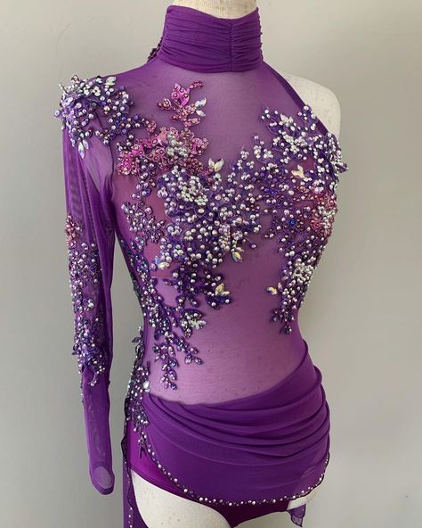 Rhinestoned appliques are a fabulous addition to all sorts of dance costumes, and they certainly look beautiful against this sheer purple mesh leotard, while also camouflaging the bra cups. This costume has a ruched collar, which ties in well with the gathers of the drape at the waist. Purple Contemporary Dance Costume, Mauve Dance Costume, Purple Jazz Dance Costumes, Lavender Dance Costume, Roller Skating Dress, Mesh Leotard, Lace Leotard, Cute Dance Costumes, Purple Leotard Rhythmic Gymnastics