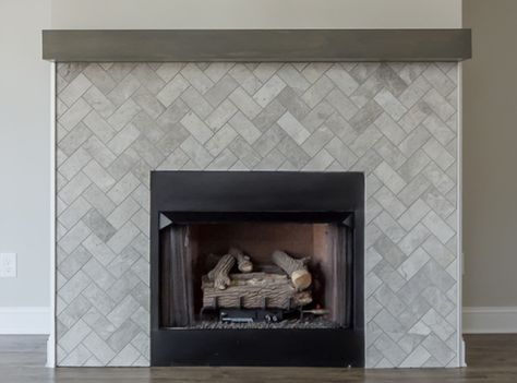 This fireplace surround features subway tile from Daltile's limestone collection installed in a beautiful herringbone pattern. Grey Herringbone Fireplace, Herringbone Tile Fireplace Surround, Tile Surround Fireplace, Herringbone Fireplace Surround, Herringbone Tile Fireplace, Tiled Fireplace Wall, Tile Around Fireplace, Herringbone Fireplace, Farmhouse Mantle Decor