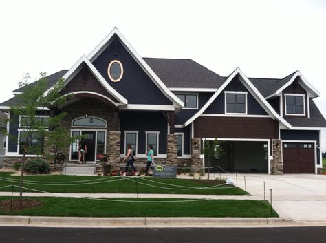 Dark navy siding with white trim, stacked stone work, black windows basically disappear, dark cherry woodwork and garage doors Dark Blue Siding, Siding With White Trim, House Expansion, Brown Garage Door, Blue Siding, Montana Homes, Garage Door Makeover, Black Windows, White Brick