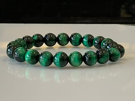 "💎 Emerald green tiger's eye gemstone bracelet made with all-natural tiger's eye beads (green color enhanced). Available in your choice of 6mm or 8mm tiger's eye bead sizes. Made with high-quality elastic stretch cord for easy on and off. ** Please read \"Bracelet Size\" instructions below before placing order ** 💎 BRACELET SIZE 💎 We make all our bracelets to actual \"wrist size\" (not \"bracelet size\" or \"bracelet length\") Select your actual Wrist Size (in inches) from the dropdown menu. Green Emerald Bracelet, Tiger Eye Bracelet For Women, Green Tiger Eye Bracelet, Tiger Eye Beaded Bracelet, Chakra Beads Bracelet, Rose Quartz Bracelet Beads, Green Tiger Eye, Tiger Eye Shaped Bead Bracelets, Green Beaded Bracelets