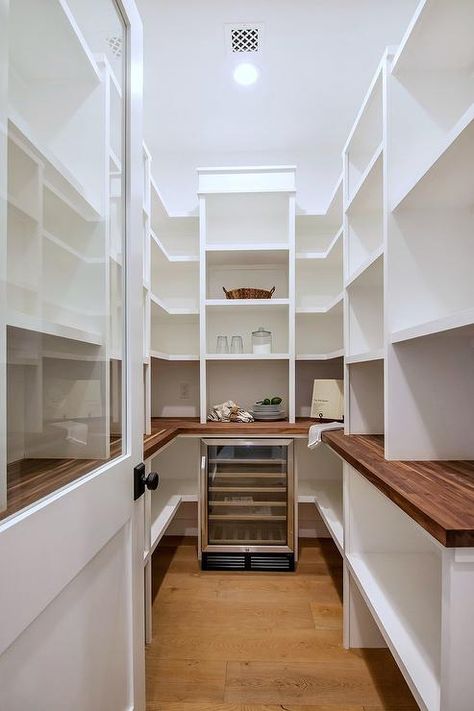 The perfect pantry built-ins ready to be filled! Here, a u-shaped kitchen pantry is designed with a butcher block top and plenty of white pantry shelves surrounding a wine cooler in the center of the walk-in design. Pantry Redesign, Walk In Pantry Ideas, Pantry Layout, White Pantry, House Pantry, Lower Cabinets, Perfect Pantry, Pantry Room, Built In Pantry