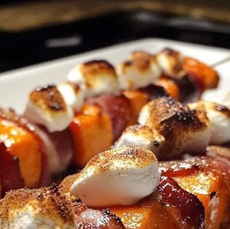 Corey Crockett on Instagram: "🍠 Candied Sweet Potato & Bacon Skewers 🥓🍬

Ingredients:

 • 2 large sweet potatoes, cut into 1-inch chunks
 • 12-16 bacon strips
 • 1/2 cup brown sugar
 • 1 tsp cinnamon
 • 1 tbsp olive oil
 • 1 cup marshmallow fluff
 • Wooden skewers (soak for 20 mins)

Instructions:

 1. Preheat oven to 400°F. Line a baking sheet.
 2. Toss sweet potatoes with olive oil and roast for 20-25 mins until tender.
 3. Partially cook bacon in a frying pan, then drain.
 4. Thread sweet potatoes and bacon (wrapped around) onto skewers.
 5. Mix brown sugar and cinnamon, then coat skewers.
 6. Bake skewers for 10-15 mins until bacon is crispy and caramelized.
 7. Heat marshmallow fluff, drizzle over skewers, and serve warm.

#SweetPotatoSkewers #SweetAndSavory" Sweet Potato Bacon Skewers, Bacon Skewers, Candied Sweet Potato, Potatoes And Bacon, Sweet Potato Bacon, Potato Bacon, Wooden Skewers, Side Order, Candied Sweet Potatoes