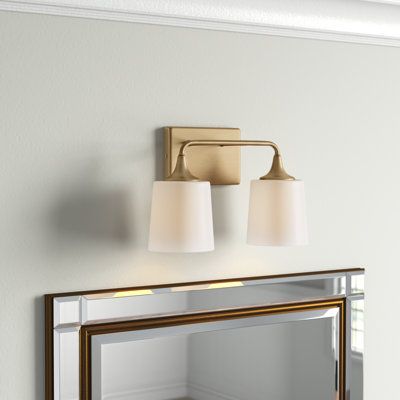 This 2-light vanity fixture aims to brightness your morning and evening routine while anchoring your bathroom with a luxe look. Rated for use in damp locations, this metal light features a square backplate, a curved, horizontal arm, and flared accents with a shiny or matte-style finish of your choice. A duo of white frosted glass shades rounds out this design, diffusing the light from compatible bulbs in an up or down direction thanks to its reverse-mounting feature. Plus, we love that it works Bathrooms With Brushed Nickel Fixtures, Silver Bathroom Fixtures, Above Mirror Bathroom Lighting, Vanity Lighting Over Mirror, Modern Traditional Bathroom, Master Bath Lighting, Kids Bathroom Design, Brass Vanity Light, Traditional Bathroom Vanity