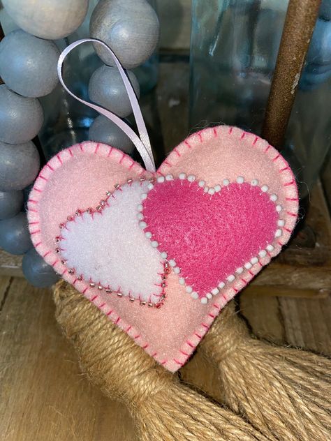 Light pink felt Valentine's Day ornaments with medium pink and white beated interlocking hearts. Valentines Day Ornaments, Felt Valentine, Beaded Hearts, Light Pink Heart, Feather Garland, Pumpkin Ornament, Felt Pumpkins, Gold Pumpkins, Pink Felt