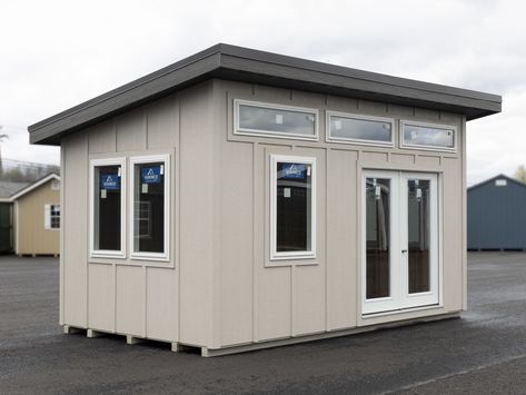 10x16 Studio 1 w LP Smart Grooveless Siding - Modern Shed Collection - Standard Features Include - Pressure Treated skids - 2×4 Pressure treated floor Joists at 16 inches on center with 5/8th Flooring - 2×4 Walls and 2x6 rafters at 16 inches on center - Back wall height 7' 9" - 6ft Prehung Modern Door - No glass - Two Large 36x36 Picture Window - Modern White Transoms across the front - Painted LP Smart Siding with Battens - Large overhangs 1ft sides and back and 18in on the front - 2/12 Roof Pitch - Standing Seam Metal Roof ------- Features above included in base price ------- ===================================================================== - Sheds Unlimited Deluxe color: Cobble Stone - 30" x 48" white vinyl casement window with Low-E, argon glass, 0.27 U-factor (egress approved; shu Small Outdoor Shed, Home Office Shed, Gym Building, Lp Smart Siding, Window Modern, Shed Studio, Home Depot Shed, Tiny Mobile House, Building A Storage Shed