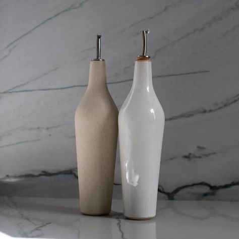 Pour and store your oil of choice in this elegant stoneware oil cruet. This classically shaped handmade bottle was designed to keep your oil as fresh as possible with its interior glaze finish and lidded stainless steel pour spout. Each piece is handmade using sand stoneware and finished in Convivial's signature ivory glaze. The glaze on the rim of the ivory option has been removed to allow the warmth of the sand clay to be highlighted. Third-party tested to be lead and cadmium free. Ivory Interior, Sand Clay, Oil Cruet, Glassware Kitchen, Ceramic Bottle, Candle Vase, Home Candles, Pottery Ideas, Vases And Vessels