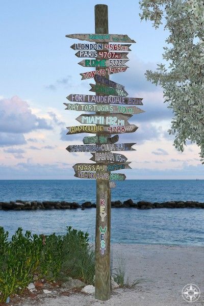 The iconic destination sign post pointing from Key West all over the world - at dusk on the beach in Fort Taylor Park. #HappierPlace #travel #travelinspiration Destination Signs, Tiki Signs, Travel Key West, Zachary Taylor, Florida State Parks, Backyard Games, Key West Florida, Beach Rentals, Sign Post