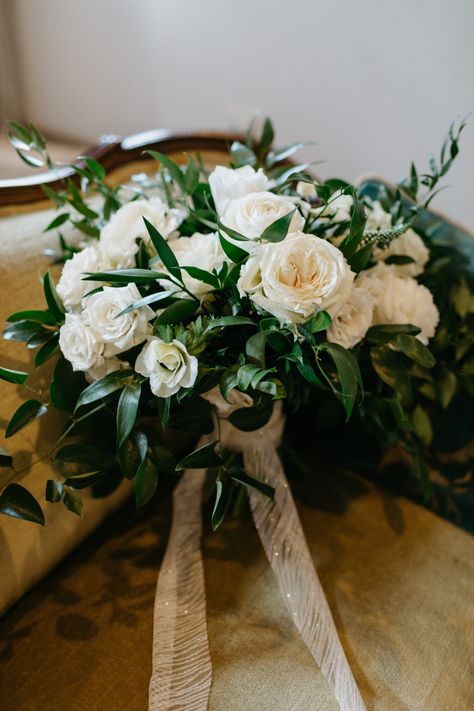 Bouquet by Soiree Floral Designs. Italian ruscus and nagi greenery, playa roses, ranunculus, white majolicas, anemones, lisianthus (no buds), white veronica. Scrap piece of Bride's dress from hemming used as ribbon. Photo by Valerie Lendvay. White Rose And Italian Ruscus Bouquet, Italian Ruscus Wedding Bouquet, Italian Bridal Bouquet, Italian Ruscus Bouquet, White Rose Bouquet With Greenery, Nagi Greenery, White Veronica, Ivory Rose Bouquet, Bouquet Styles