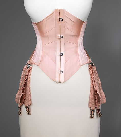 Key Info: Date: ca. 1908 Country: America  Materials: Silk, Cotton, Metal, Whalebone Designer: J. B. Corset Company Accession Number: 2009.300.3037a–c I am interested in this corset because it is very plain with a couple of colours and the straps seem very elaborate with what looks like lace sewn on giving detail. Edwardian Corsets, 1900s Fashion, Lingerie Vintage, Pink Corset, Corset Fashion, Vintage Corset, Corsets And Bustiers, Costume Collection, Retro Mode