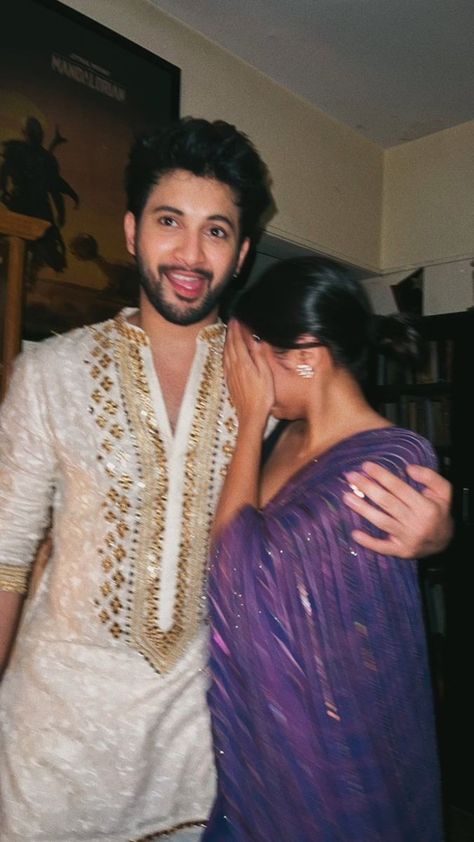 An Indian couple embraces in front of a stunning backdrop of vibrant, colorful architecture and lush greenery. The man is dressed in traditional Indian clothing, while the woman wears a beautiful saree. The warm hues of the sunset cast a golden glow over the scene, adding to the romantic and picturesque aesthetic Dating Dr Dil, Old School Romance, Indian Couple Aesthetic, School Romance, Romance Couple, Desi Vibes, Desi Love, Indian Couple, Pani Puri