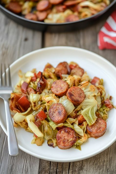 Indulge in the amazing flavors of cabbage and sausage with onions! This classic dish is hearty, savory, and perfect for any meal of the day. The combination of tender cabbage, flavorful sausage, and sweet caramelized onions creates a mouthwatering experience that will satisfy all your cravings. Whether you're looking for a comforting weeknight dinner or just want to try something new, this recipe is sure to impress your taste buds. Beef Sausage And Cabbage Recipes, Smothered Cabbage And Sausage, Cabbage Kielbasa Recipes, Cabbage And Kielbasa Recipes, Cabbage Sausage Potatoes, Cabbage And Sausage Recipes, Cabbage Sausage Potato, Bacon And Cabbage, Cabbage Sausage