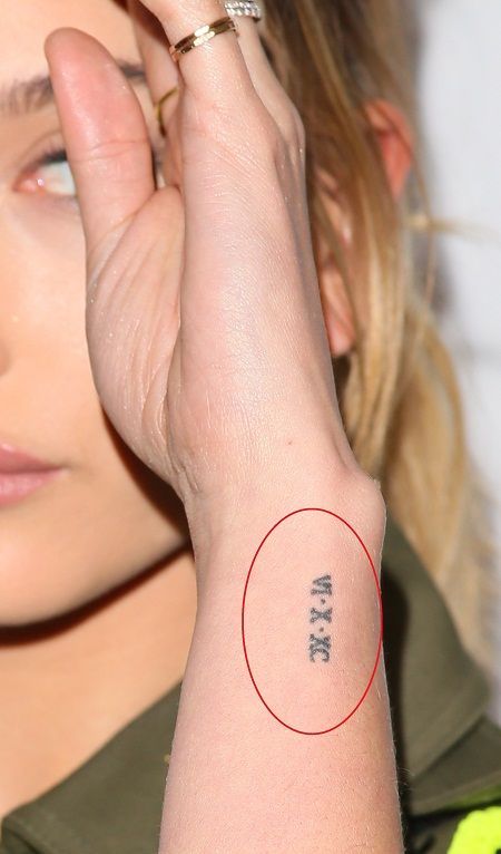 The Roman numeral tattoo stands for June 10, 1990, which is the date when her parents got married. Hailey Bieber Wrist Tattoo, Hand Roman Numeral Tattoo, Roman Numeral Seven Tattoo, Tiny Date Tattoos For Women, Roman Numeral Tattoo Meaning, Roman Numeral Tattoos Women, Wrist Roman Numeral Tattoo, Small Date Tattoos, Dainty Roman Numeral Tattoo