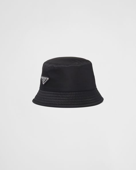 Adorned with the iconic enameled metal triangle logo, this bucket hat is made from Re-Nylon, a regenerated nylon yarn produced through a process of recycling and purifying plastics recovered from the ocean, as well as fishing nets and textile fibers. Prada Bucket Hat, Prada Hat, Fabric Bucket, Prada Collection, Custom Belt, Hat Men, Mens Lifestyle, Triangle Logo, Women Essentials