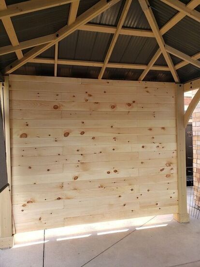 I added a privacy wall/ T.V. to our gazebo by framing up one side of the gazebo and adding pine tongue and groove to the inside. Not only does it create privacy but it's the perfect place for mounting a t.v. , hiding the not so pretty part of our backyard behind it, and blocking the strong winds we get....and it gives the gazebo a cozy feel.Although there are many other ways we could've done this wall, we did it this way for our home, weather and purpose. And we love it. It's getting a… Privacy Gazebo Ideas, Patio Privacy Wall With Tv, Outdoor Patio Tv Wall Ideas, Porch Tv, Privacy Screen Ideas, Gazebo Bar, Gazebo Side Panels, Gazebo Privacy, Tongue And Groove Walls