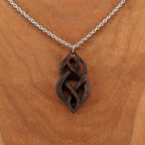 "This wood pendant is hand carved from maple or walnut wood. Lightweight and ideal for daily wearing. 18\" decorative stainless steel chain included. Wood measures approximately 1.75\" tall x 1.0\" wide Available in maple (light) or walnut (dark). Free shipping for US customers! Made and shipped from the United States. Gift bag included! Also available in earrings: https://www.etsy.com/listing/696957771/wood-earrings-hand-carved-celtic Interested in wholesale? No problem! Send me a message and I Wood Necklace Pendant, Wooden Jewelery, Carved Necklace, Dremel Crafts, Beach Stones Jewelry, Wood Jewelery, Jewelry Wood, Celtic Earrings, Dremel Wood Carving