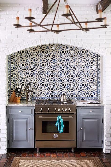 Amazing kitchen features a ceiling accented with rustic wood beams situated over a white brick wall fitted with an arched alcove filled with a stainless steel stove under a blue mosaic tiled backsplash next to an integrated microwave. White Brick Kitchen, Blue Mosaic Tile, Kitchens Ideas, Mosaic Tile Backsplash, Brick Kitchen, Blue Tile, Classic Kitchen, Brick Walls, White Brick