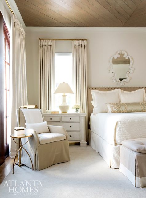 The master bedroom, painted Benjamin Moore’s Seapearl, is layered with various shades of ivory and is one of Renee’s favorite rooms in the house. The bed was custom designed and features a Cowtan & Tout fabric on the headboard. The mirror above the bed is through Made Goods and the chair is through LEE Industries. Bedside chest through Tritter Feefer, rug through Designer Carpets. The shams and coverlet are Peacock Alley. Bed Windows On Each Side, French Transitional Bedroom, Traditional Home Interiors Bedroom, Windows On Both Sides Of Bed, Windows On Each Side Of Bed, Chair Beside Bed, King Bed Between Two Windows, Chair Next To Bed, Caracole Bedroom