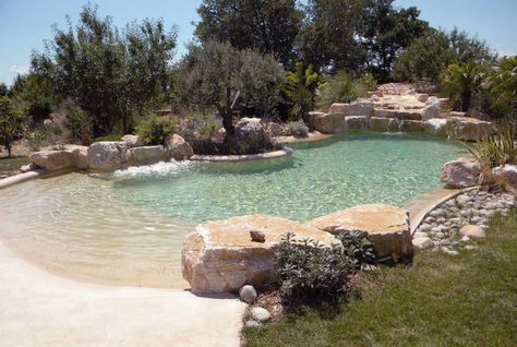 lagoon beach pool- add more tropical plants around, CHLORINE-FREE WATER FILTRATION, UNDERWATER LIGHTS, INTEGRATED WHIRLPOOLS, CASCADES, CURRENT STREAMS, UNDERWATER MUSIC SYSTEMS, WATERFALL AND A SPECIAL FLOOR AND SIDE WALL SURFACE APPLICATION WHICH IS NATURAL SAND BASED TO ACHIEVE THE UNIQUE BEAUTIFUL ORGANIC "BEACH" LOOKING ATMOSPHERE. Underwater Music, Swimming Pool Pond, Beach Entry Pool, Building A Swimming Pool, Natural Swimming Ponds, Lagoon Pool, Pool Finishes, Backyard Beach, Swimming Pond