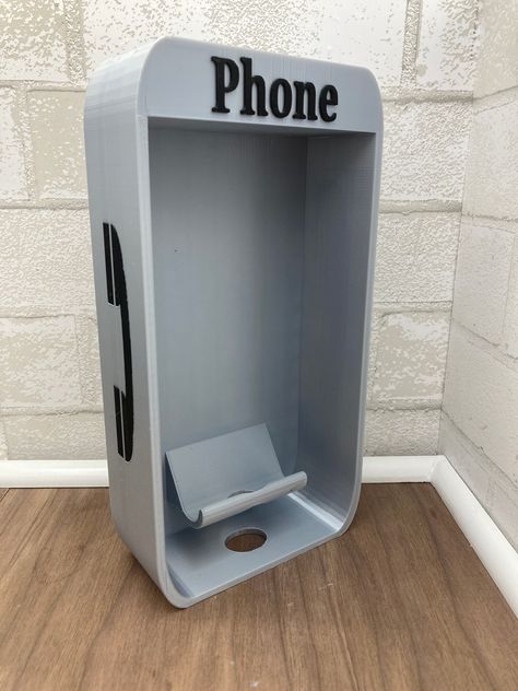 Add a touch of nostalgia to your workspace with our 3D Printed Cell Phone Booth Holder. This unique desk accessory combines vintage charm with modern functionality, making it the perfect addition to your office decor. **Product Features - **Unique Design Modeled after a classic telephone booth, this holder adds a whimsical touch to any desk or workspace. - **High-Quality 3D Print Crafted using advanced 3D printing technology, ensuring durability and intricate details. - **Functional and Stylish Keeps your cell phone upright and easily accessible, while also serving as a stylish decor piece. - **Perfect Gift Ideal for tech lovers, office workers, and anyone who appreciates unique and practical accessories. - **Versatile Use Suitable for holding various phone sizes, making it a versatile add Cute Office Desk Decor At Work, Useful 3d Prints Products, 3d Printed Office Accessories, 3d Print Organizer, 3d Printed Business Card Holder, Phone Stand 3d Print, 3d Printed Switch Stand, Office Accessories Design, 3d Printed Gifts