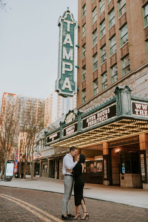 Bride in all black standing with groom in front of tampa theater sign Downtown Rooftop Engagement Photos, Downtown Tampa Elopement, Hyde Park Tampa Photoshoot, In Town Photoshoot, Tampa Theatre Photoshoot, Engagement Photos Theatre, Down Town Photoshoot Couples, Editorial Downtown Engagement Photos, Downtown Tampa Photoshoot