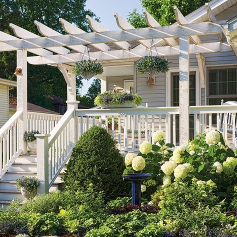 We love how these homeowners dressed up the entrance of their one-story home by adding this fantastic pergola and front porch, painted white to match the trim. Cool blues and whites used in the landscape continue the calming, friendly essence of the space. How about that Incrediball hydrangea out front too?! Wisteria Pergola, White Pergola, Vinyl Pergola, Small Pergola, Pergola Curtains, Cheap Pergola, Pergola Swing, Pergola Ideas, Pergola Attached To House