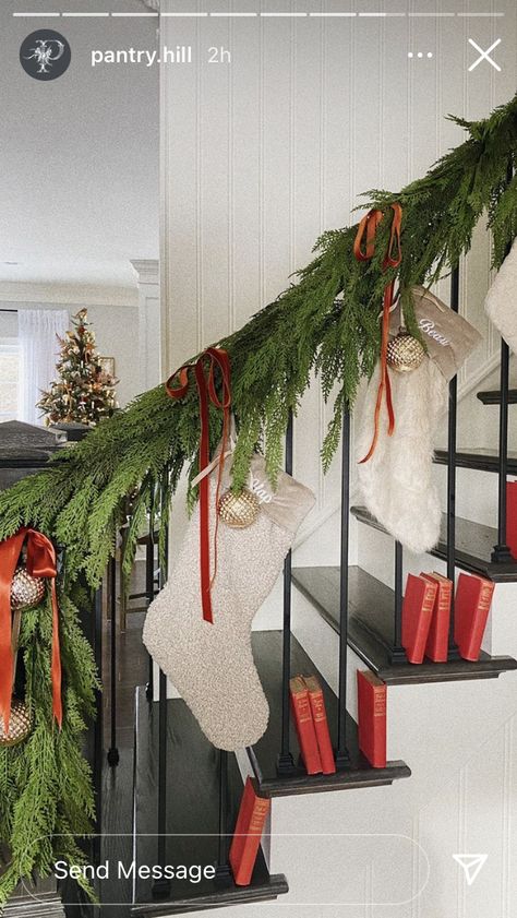 Stockings Hanging From Stairs, Christmas Stocking On Stairs, Stockings On Railing, Staircase Stocking Ideas, Garland And Stockings On Staircase, Curved Staircase Christmas Decor, Stocking On Stairs, Christmas Stockings On Stair Railing, Christmas Doorway Garland