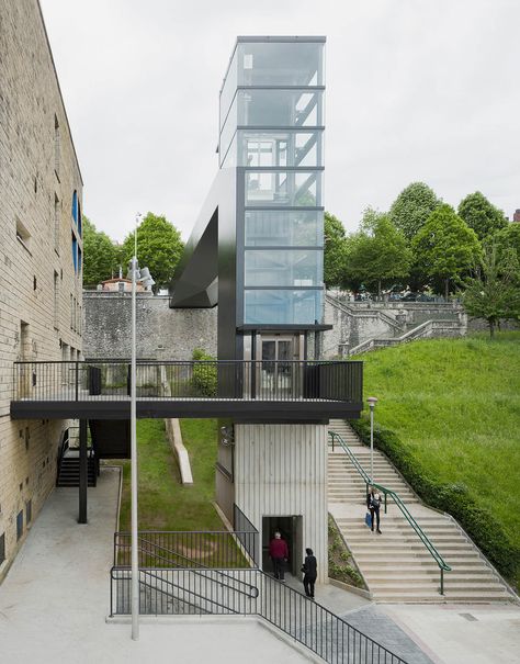 Built by VAUMM in Hernani, Spain Urban accessibility improvement between Latxunbe-Berri neighborhood and Urbieta street  In the natural evolution of a... Elevator Design, Concrete Walkway, Glass Elevator, Pedestrian Bridge, Bridge Design, Urban Spaces, Modern Landscaping, Staircase Design, Architectural Inspiration