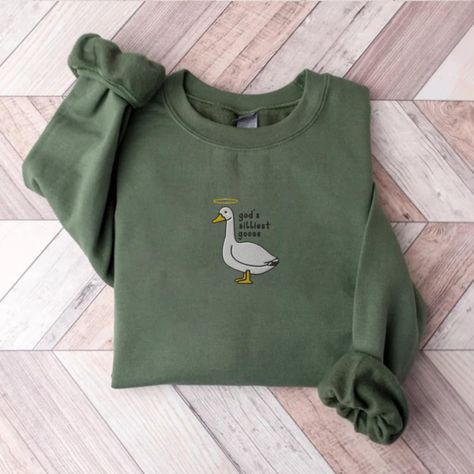 Embroidery God's silliest Goose Sweatshirt| Funny Sweatshirt | Embroidered Goose Crewneck | Cute Gift For Mom| Funny Meme Goose Sweater A sturdy and warm sweatshirt bound to keep you warm in the colder months. A pre-shrunk, classic fit sweater that's made with air-jet spun yarn for a soft feel and reduced pilling. 🤍Here you can see all our Silly Goose products🤍 https://www.etsy.com/shop/goodpeopleclub?ref=seller-platform-mcnav&section_id=40802789 Product Details ✨ * Made from a blend of 50% cotton and 50% polyester * Pre-shrunk for your convenience * Classic fit * 1x1 athletic rib knit collar with spandex for added durability * Air-jet spun yarn with a soft feel and reduced pilling * Double-needle stitching on the collar, shoulders, armholes, cuffs, and hem for added strength Sizing👚 Ou Goose Sweatshirt, Embroidery Crewneck, Embroidery Hoodie, Silly Goose, Embroidered Gifts, Embroidery Sweatshirt, Embroidered Clothes, Custom Sweatshirts, Embroidered Hoodie