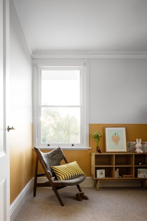 A bookshelf, occasional chair and half-painted yellow wall make this kids' bedroom a happy one. Half Wall Painting, Yellow Boys Room, Yellow Kids Bedroom, Yellow Playroom, Half Wall Ideas, Flat Decor Ideas, Roof Section, Yellow Kids Rooms, Renovated Victorian