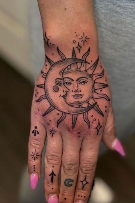 The sun and moon hand tattoo is a stunning tattoo idea for women who love celestial designs. This small tattoo for female hands is a perfect blend of balance and harmony, representing duality in a delicate, meaningful way. Hand Spiritual Tattoo, Spiritual Tattoos Hand, Hand Tattoos With Butterflies, Moon And Sun Hand Tattoo, Top Of Hand Tattoos For Women Unique, Arm And Hand Tattoos For Women, Women Hand Tattoo Ideas Unique, Cover Up Tattoos Hand, Moon Hand Tattoos For Women