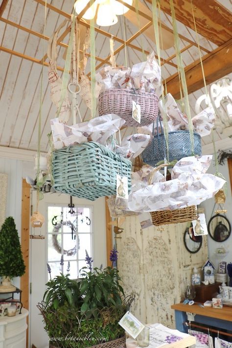 Spring baskets in pastel colors as ceiling display above a table in the garden shed Easter Ceiling Decorations, Easter Store Display, Easter Store Window Display, Ceiling Display, Easter Window Display, Table In The Garden, Spring Baskets, Spring Window Display, Vintage Booth Display