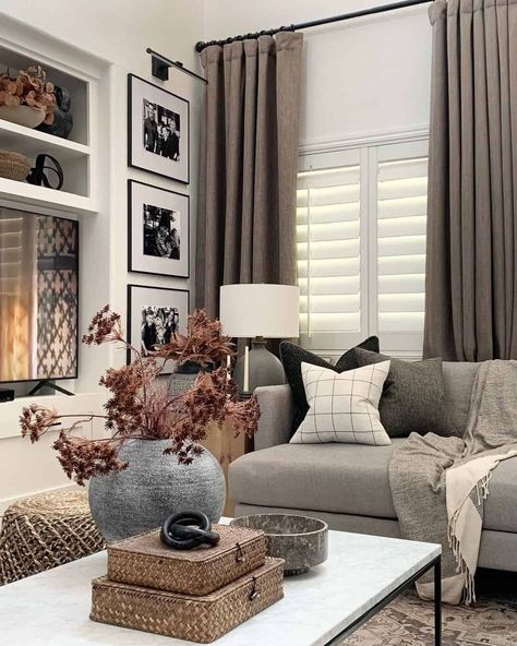 This comfortable living room is styled with beautiful burnt orange fall foliage in a round gray vase. The vase rests on a modern marble coffee table, alongside woven square baskets and a marble bowl. A neutral throw and checkered accent pillow decorate the contemporary gray couch...   Image: jaimebydesign Gray Couch, Living Room Inspo, New Living Room, Couches Living Room, Cozy Living Rooms, A Living Room, Living Room Inspiration, Home Decor Inspiration, Home Interior