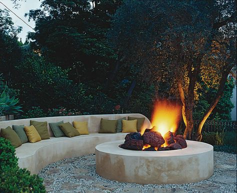 Designing with fire features: The fire sits in a 12-foot circle of flagstone and gravel, the same materials used for the path that winds up to this cozy hideaway. Rounded chunks of lava stone break up the sleek design giving the fire pit a more authentic, rustic feel. Photo by Tim Street-Porter. #gardendesign #autumn #firepit Fire Pit Gallery, Bonfire Pits, Sunken Fire Pits, Fire Pit Materials, Outdoor Fire Pit Designs, Chill Zone, Fireplace Garden, Round Fire Pit, Fire Pit Seating