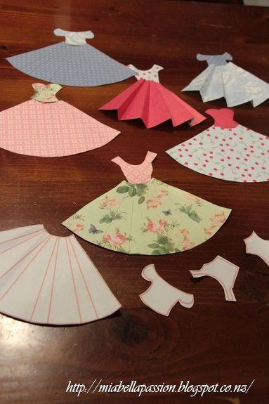 I have always loved these cute paper dresses... and thought I would make a mini bunting of them for my Granddaughter Emilee.   Pattern by Jane CS. is on Mia Bella Passions blog. Jane CS uses her pattern to make the most gorgeous cards.  But I thought they would make a cute bunting.   Cut out the pattern pieces. Use as a template on your pre-chosen pretty papers.   Rules the pleats in pencil.   Cut out the skirt and bodice pieces.   Use  ruler to crease the skirt pleats, and glue bodice… Diy Paper Dress, Make A Paper Flower, Diy Bunting, Paper Dress Patterns, Craft Ideas For Beginners, Bunting Diy, Paper Flower Wreaths, Mother Daughter Projects, Paper Towel Tubes