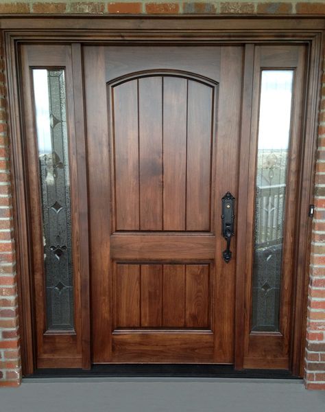 Leaded glass sidelights add a distinctive flair to this select alder door unit with arched top rail and raised panels with v-grooves.  Glass by Scottish Stained Glass. French Country Doors Entrance, Tradition House, Craftsman Style Front Doors, House Entry Doors, Door Renovation, Exterior Doors With Sidelights, Brown Front Doors, Double Front Entry Doors, Cabin Storage