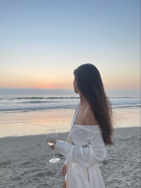 Aesthetic photo shoot Beach girl sunset ocean wine glass white silk skirt blouse fashion summer that girl Wine And Beach Pictures, Beach Picnic Photoshoot Ideas, Photoshoot With Wine Glasses, Beach Wine Photoshoot, Wine Beach Aesthetic, Wine Glass Photoshoot, Birthday Beach Pictures, Beach Photoshoot Aesthetic, Hijabi Beach