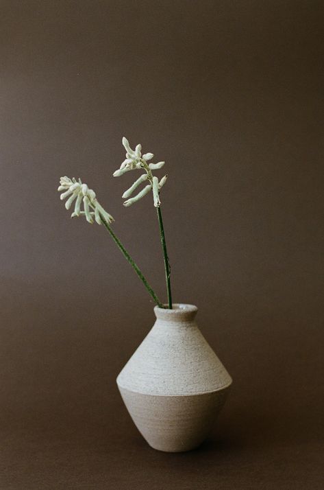 Echoing the striking silhouettes of Greek pottery, the Angular Ceramic Vase in Beige stands as a handcrafted marvel brought to life by skilled artisans in Europe. This multi-purpose vessel invites you to showcase its beauty by styling it with blooming buds or rustic branches. Due to its handmade nature, no two pieces are the same. Round Kitchen Table Styling, Angular Ceramics, Bud Vase Ceramic, Pottery Vase Shapes, Vase Product Photography, Ceramic Planters Indoor, Ceramics Vase Ideas, Small Ceramic Vase, Japandi Vase