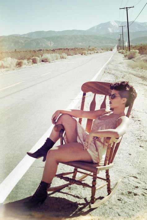 Natalya Oliver of Project Primal.  Photographer: Jamie Blank  Desert, rocking chair, slip, nudes, mohawk, witchy woman Chair In Desert Photoshoot, Woman Sitting On A Rock, Desert Rock N Roll Aesthetic, Desert Mirror Photography, Whiskey Bars, Chair Photoshoot, Outdoor Boudiour Ideas River, Senior Photography Inspiration, Portraits Photography