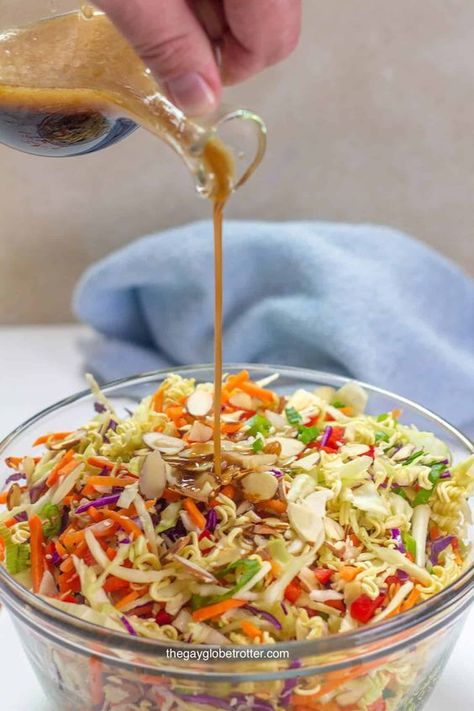 We love making this easy, crunchy, ramen noodle salad recipe for potlucks. This simple and delicious salad has an Asian sesame and soy sauce dressing tossed with cabbage and other delicious vegetables! #gayglobetrotter #ramen #ramennoodlesalad #salad #noodlesalad #sidesalad #saladrecipe Crunchy Ramen Noodle Salad, Ramen Cabbage Salad, Asian Noodle Salad Recipe, Asian Ramen Noodle Salad, Asian Sesame Dressing, Soy Sauce Dressing, Napa Cabbage Salad, Ramen Toppings, Asian Noodle Salad