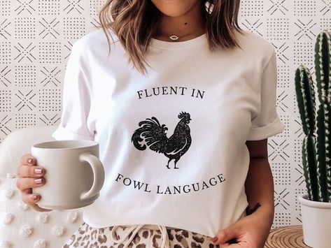 #FarmAnimalTees #ChickenLoversGift #FunnyChickenShirt #BlockPrintedShirt #FloralTShirt #VintageBotanical #CelestialTee #HumorousTees #GraphicTees #NatureInspiredFashion #AnimalLoversApparel #WhimsicalTees #BotanicalFashion #UniqueGraphicShirts #CasualChicTees Fluent In Fowl Language Svg, Fowl Language, Botanical Fashion, Crazy Chicken, Chicken Shirt, Crazy Chicken Lady, Chicken Lady, Chicken Shirts, Funny Chicken