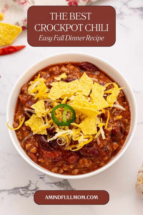 Bowl of slow cooker chili topped with cheese with title text overlay that reads The Best Crockpot Chili Easy Fall Dinner Recipe. Crockpot Ground Beef Chili, Best Crockpot Chili Recipe Award Winning, Slow Cooker Chili Recipe Ground Beef, Best Chili Recipe Award Winning Crockpot, Beef Chili Recipe Crockpot, Best Chili Recipe Award Winning, Slow Cooker Beef Chili, Healthy Chili Crockpot, Beef Chili Crockpot