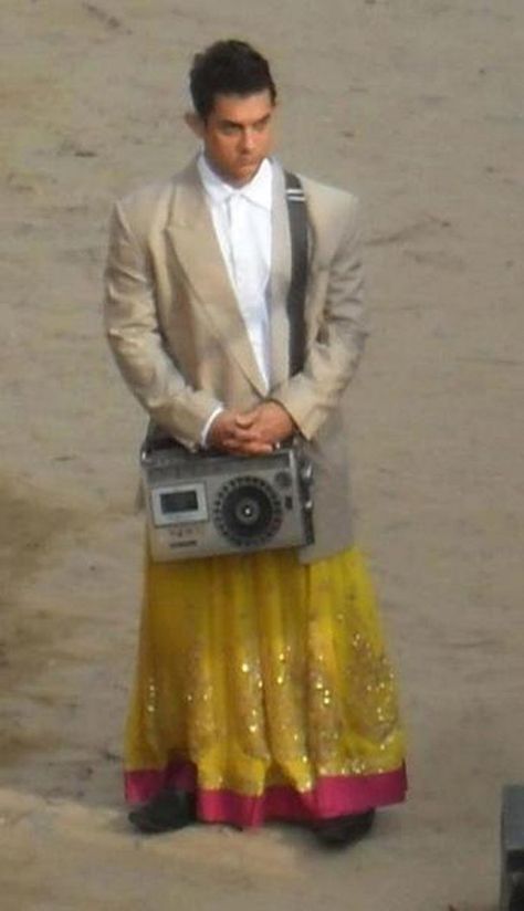 Aamir Khan, who is shooting for Rajkumar Hirani’s “P.K.” in Rajasthan, has used a radio bought from Chor Bazaar here for one of the sequences in the film. The 47-year-old was spotted wearing a skirt and a blazer during the film shoot and also carrying a radio in his hand. Retro Bollywood Theme Party Outfit, Retro Bollywood Outfits, Retro Bollywood Theme, Retro Bollywood Fashion, Bollywood Theme Party Outfit, Movie Character Outfits, Bollywood Theme Party, Bollywood Retro, Bollywood Theme